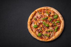 Delicious pizza with sausage, cheese, tomatoes, salt, spices and herbs photo
