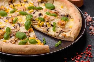 Delicious pizza with corn, cheese, tomatoes and mushrooms, salt, spices and herbs photo