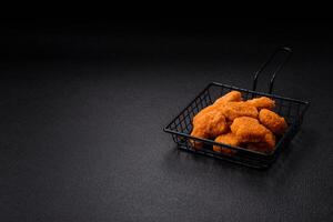 Delicious fresh crispy chicken nuggets on a dark concrete background photo