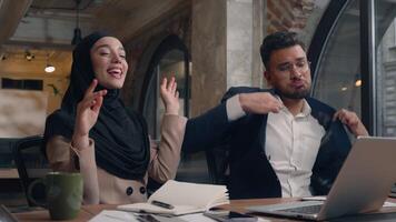 Arabian muslim islamic woman in hijab Indian man business partners corporate colleagues winners male female happy joyful carefree businesswoman businessman dancing at office dance celebrate have fun video