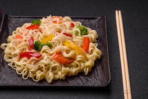 Delicious Asian dish rice noodles or udon with vegetables, spices and herbs photo