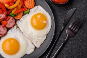 Delicious nutritious breakfast with fried eggs, sausage, steamed vegetables photo