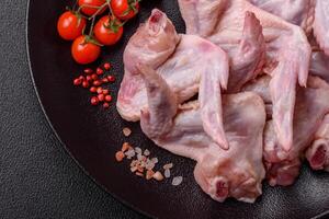 Fresh chicken wings with salt, spices and herbs photo