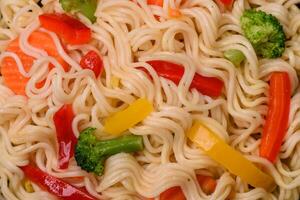 Delicious Asian dish rice noodles or udon with vegetables, spices and herbs photo