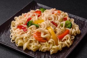 Delicious Asian dish rice noodles or udon with vegetables, spices and herbs photo