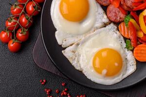Delicious nutritious breakfast with fried eggs, sausage, steamed vegetables photo