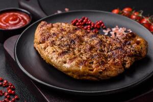 Delicious juicy pork steak with salt, spices and herbs photo