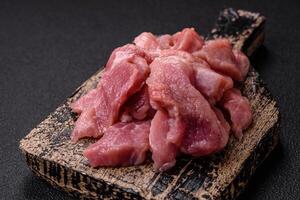 Slices of raw pork or turkey meat with salt, spices and herbs photo