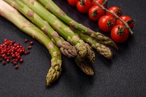 Sprigs of raw green asparagus as an ingredient for preparing a healthy breakfast photo