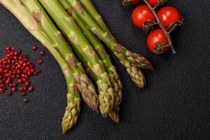 Sprigs of raw green asparagus as an ingredient for preparing a healthy breakfast photo