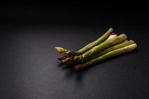 Sprigs of raw green asparagus as an ingredient for preparing a healthy breakfast photo