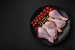 Raw chicken legs with salt, spices and herbs photo