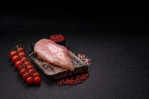 Raw chicken fillet with salt, spices and herbs photo