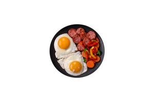 Delicious nutritious breakfast with fried eggs, sausage, steamed vegetables photo