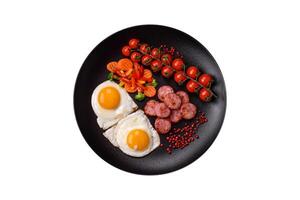 Delicious nutritious breakfast with fried eggs, sausage, steamed vegetables photo