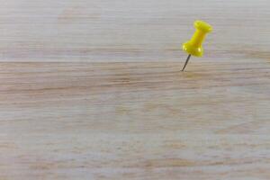 Yellow pin on the wood photo