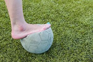 niña descalzo y antiguo fútbol pelota foto