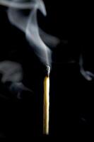 Wooden match burning on a black background photo