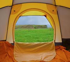 Tent standing on a grass in mountains photo