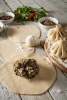 Close up to Caucasian khinkali dumplings dish served on plate. Background with ingredients and scattered spices photo