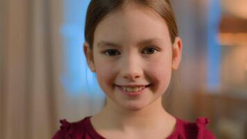 Close up portrait little Caucasian girl daughter child schoolgirl happy joyful toothy smiling female pupil school kid orphan baby face purity smile home children custody adoption pediatric health care video