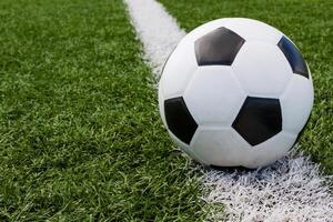 soccer ball in the field on the white line photo