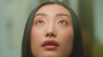 stänga upp asiatisk kvinna ansikte ung kinesisk koreanska trogen drömma flicka ser upp lugna fredlig känsla ledsen japansk kvinna lady studerande flickvän tror framtida hoppas be tro dröm se överväga video