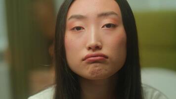 Close up face portrait Asian young woman bored upset sad emotions lonely alone depressed Korean Chinese girl female student homeowner Japanese lady looking at camera worried melancholy stress problem video