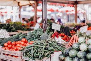 Bustling outdoor market filled with vendors selling fresh fruits, vegetables, and flowers photo