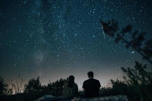 Pareja estudio de las estrellas en cobija en prado, contando disparo estrellas en claro verano noche foto