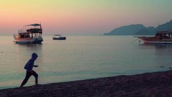 Dad with children running along the beach. Healthy lifestyle. Beautiful sunrise over the Mediterranean Sea. video