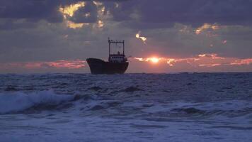 mooi zonsondergang over- de middellandse Zee zee. de stralen van de zon schijnen door de wolken. een schip Aan de horizon. 4k video