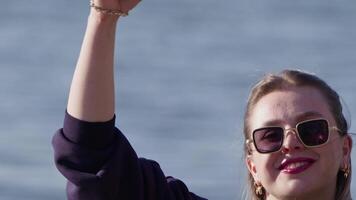 young girl making a heart sign with her hand on the beach video