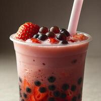 Close up view of refreshing strawberry bubble tea with tapioca pearls visible at the bottom in the plastic cup with straw photo