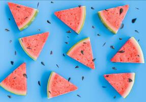 Sliced Watermelon Pieces with Seeds on Bright Blue Background photo