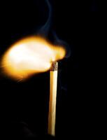 Wooden match burning on a black background photo