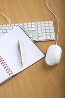 Modern aluminum computer keyboards, mouse and notebook photo