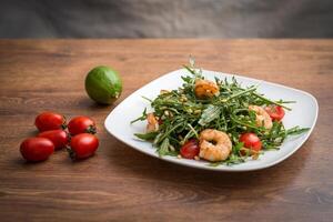 A delicious salad with arugula, cherry tomatoes and shrimps. photo