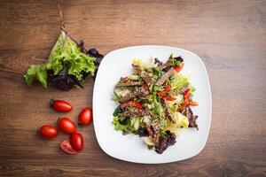 Fresh salad with grilled beef , arugula and tomato. Top view photo