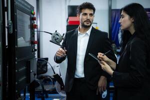 Businessperson of factory industry inspection and testing of robots arm for use in large-scale complex manufacturing industries. photo