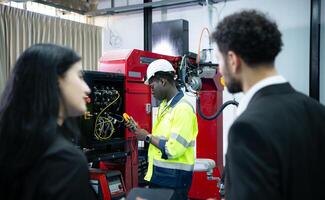 técnicos son presentando industrial mano robots a persona de negocios de fábrica industria quien será utilizar ellos en Gran escala complejo fabricación operaciones. foto