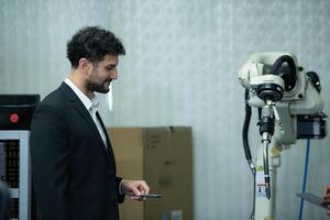 Businessman of factory industry inspection and testing of robots arm for use in large-scale complex manufacturing industries. photo