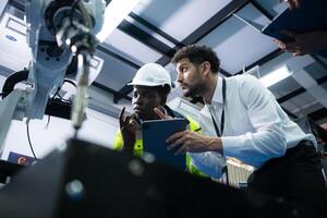 Technicians are introducing industrial hand robots to businessperson of factory industry who will use them in large-scale complex manufacturing operations. photo