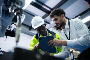 técnicos son presentando industrial mano robots a persona de negocios de fábrica industria quien será utilizar ellos en Gran escala complejo fabricación operaciones. foto