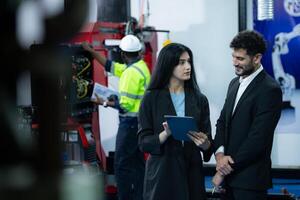 Portrait of businessperson of factory industry inspection and testing of robots arm for use in large-scale complex manufacturing industries. photo