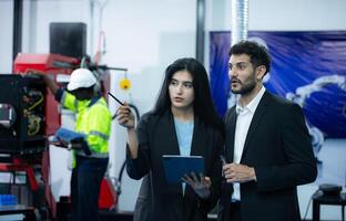 Portrait of businessperson of factory industry inspection and testing of robots arm for use in large-scale complex manufacturing industries. photo