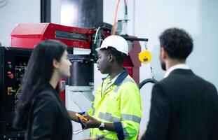 técnicos son presentando industrial mano robots a persona de negocios de fábrica industria quien será utilizar ellos en Gran escala complejo fabricación operaciones. foto