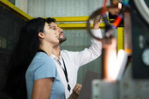 Businessperson of factory industry inspection and testing of robots arm for use in large-scale complex manufacturing industries. photo