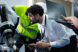 técnicos son presentando industrial mano robots a persona de negocios de fábrica industria quien será utilizar ellos en Gran escala complejo fabricación operaciones. foto