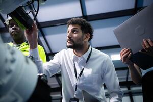 Technicians are introducing industrial hand robots to businessperson of factory industry who will use them in large-scale complex manufacturing operations. photo